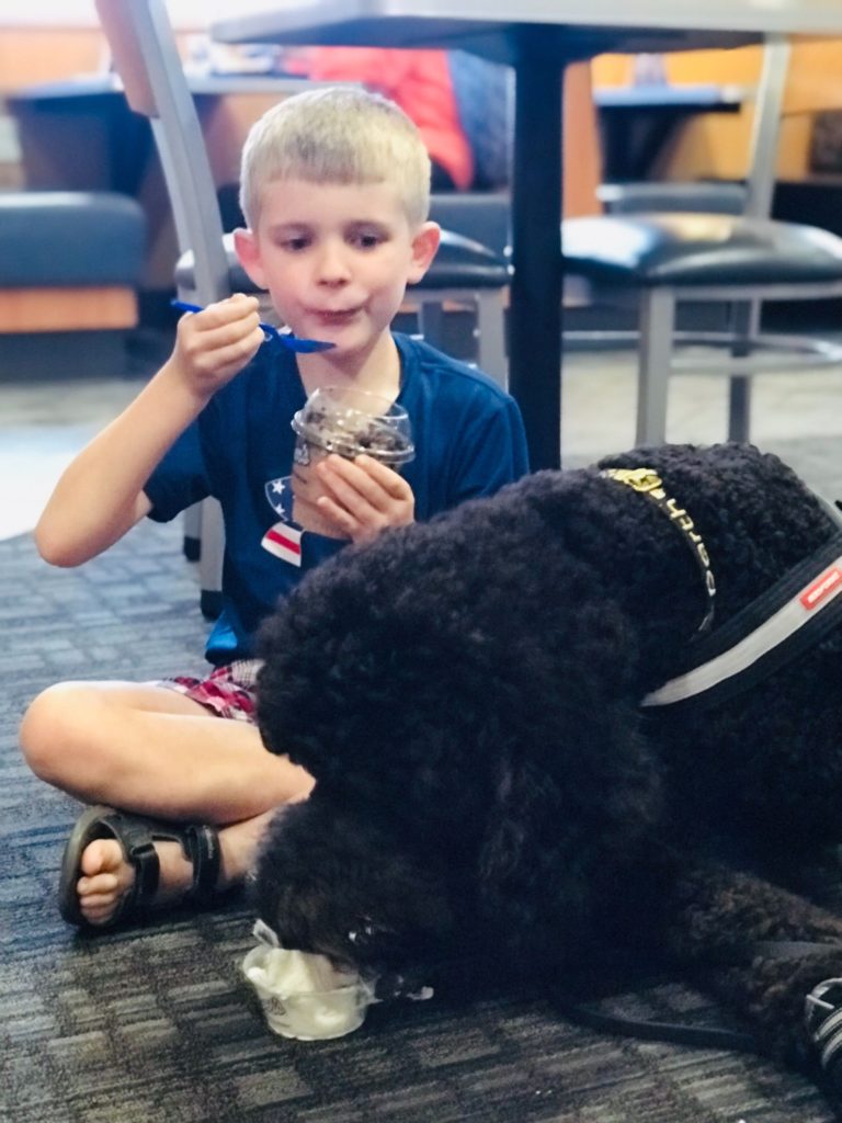 autism service dog and child blowing bubbles